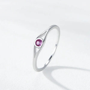 Silver ring with a pink gemstone on a light gray background
