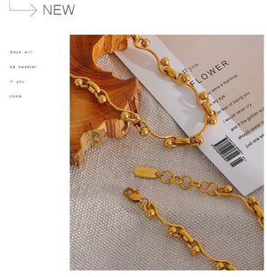 Gold bracelets on a textured surface with a book underneath