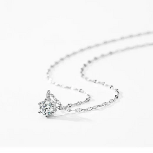 Silver necklace with a diamond pendant on a white background