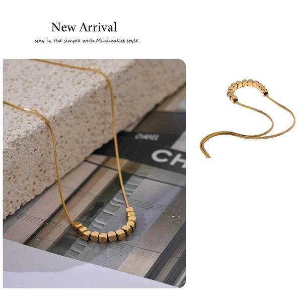 Gold necklace on a textured surface with 'New Arrival' text