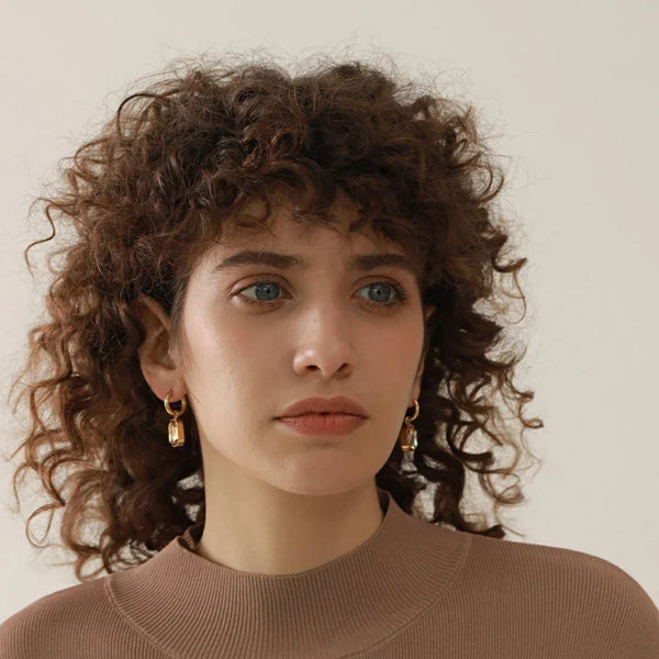 Gold-plated hoop earrings with emerald green rectangular crystal drops