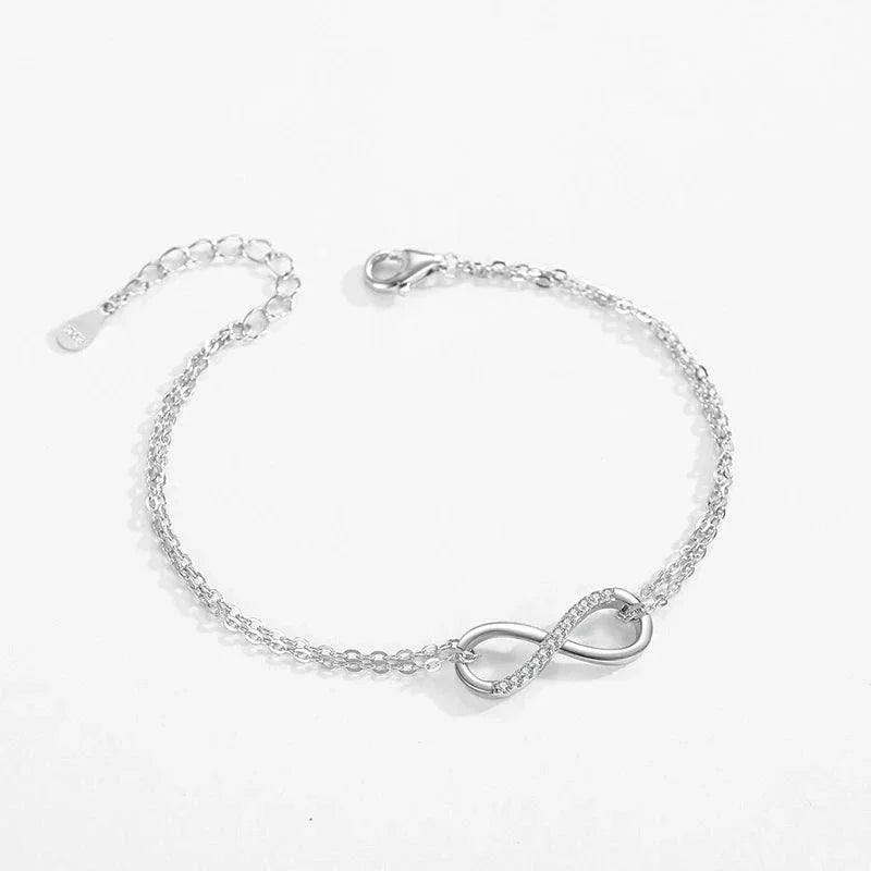 Sterling silver infinity symbol bracelet with adjustable chain on white background