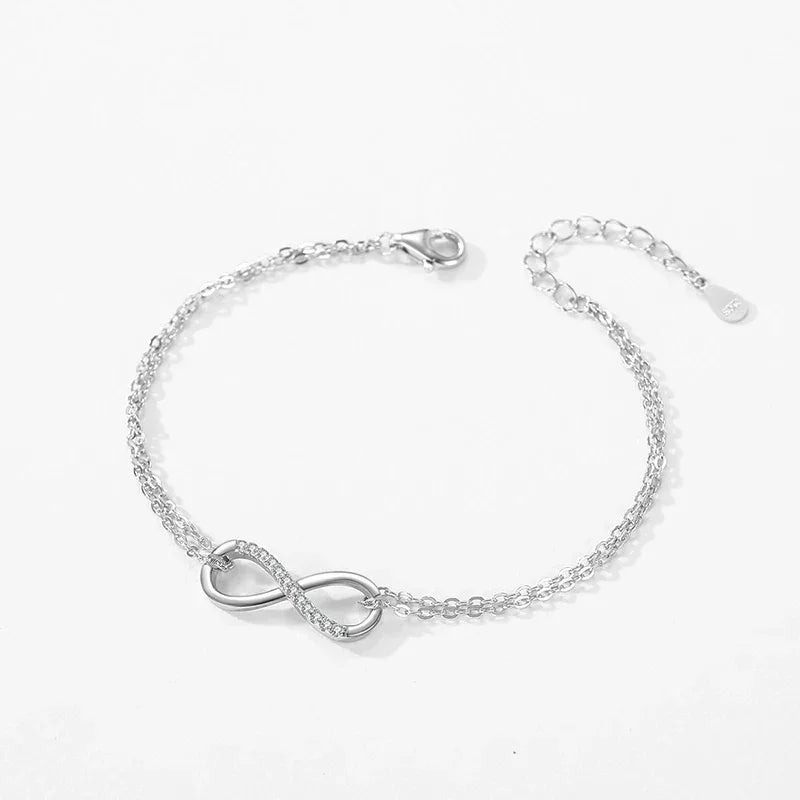 Sterling silver infinity symbol bracelet with delicate chain on white background
