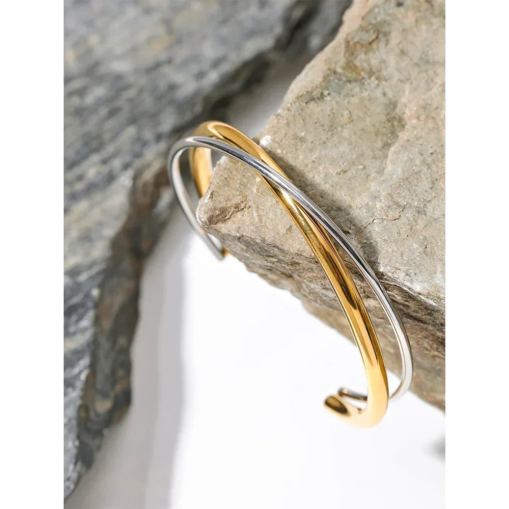 Elegant 925 silver and 18K gold-plated cuff bracelet on natural stone background