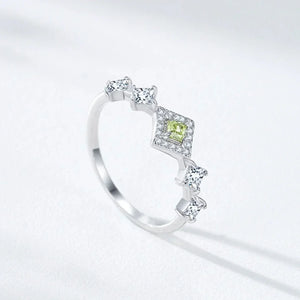Silver ring with a green gemstone on a light gray background-TM & CO. JEWELS 