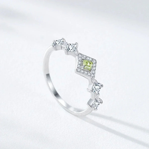 Silver ring with a green gemstone on a light gray background-TM & CO. JEWELS 
