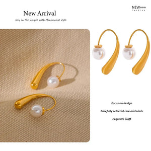 Gold earrings with pearls on a beige background, labeled as a new arrival from New Fashion.