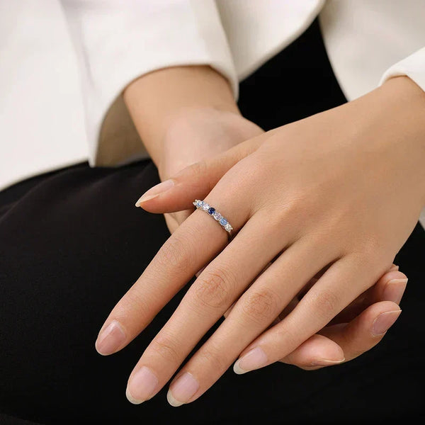 Close-up of a hand wearing a ring with a black background