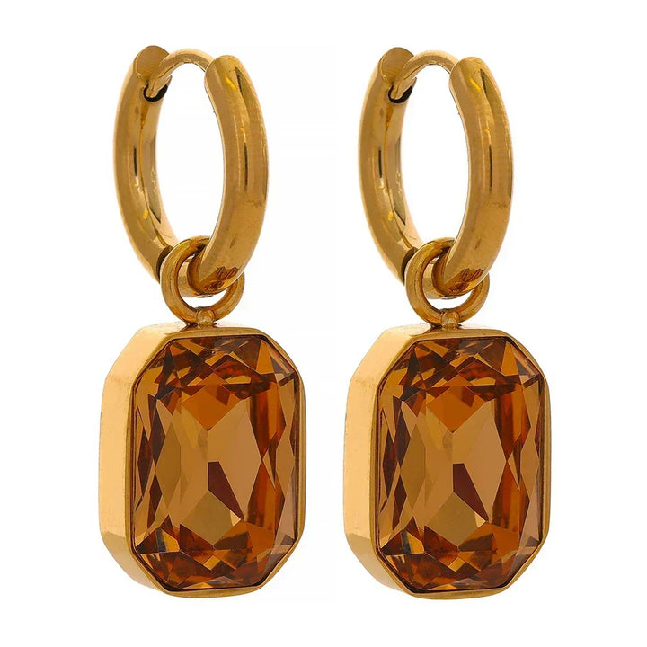 Gold hoop earrings with amber-colored gemstones on a white background.