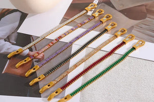 Colorful beaded bracelets with gold clasps on a magazine background