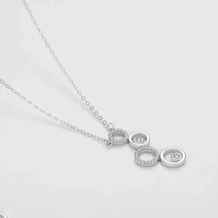 Silver necklace with three interlocking rings pendant on a light gray background-Shining CZ Bubble Pendant Necklace - TM & CO. JEWELS.
