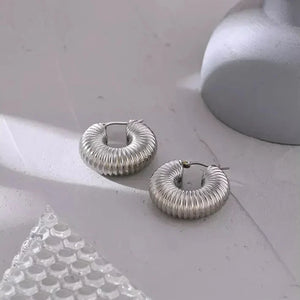Textured 925 silver hoop earrings on a light surface, modern minimalist jewelry