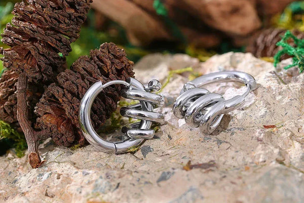 Silver hoop earrings with knot design on textured stone background