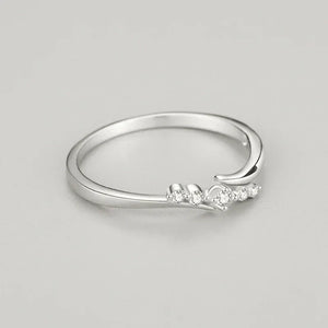Minimalist 925 silver ring with delicate cubic zirconia stones on a plain background
