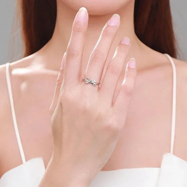 Woman wearing a delicate 925 silver bow ring on her hand, minimal jewelry style