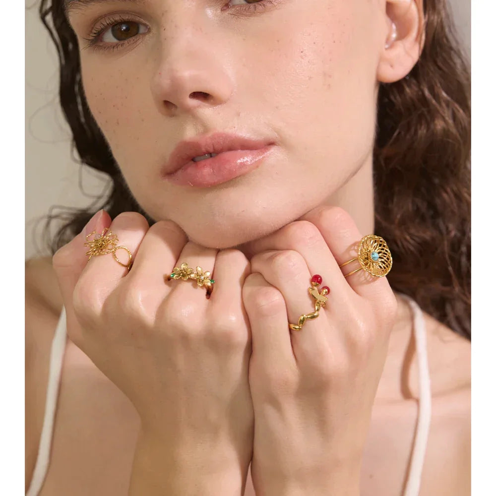 Close-up of a woman's face with gold rings on her fingers